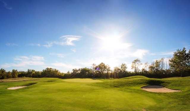 A sunny day view of a green at Pipestone Golf Club.