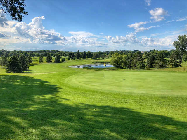 A sunny day view of a hole and a pond in background at Montgomery National Golf Club.