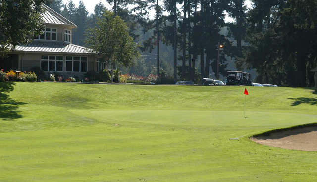 A sunny day view of a hole and the clubhouse at Eagles Pride Golf Course.