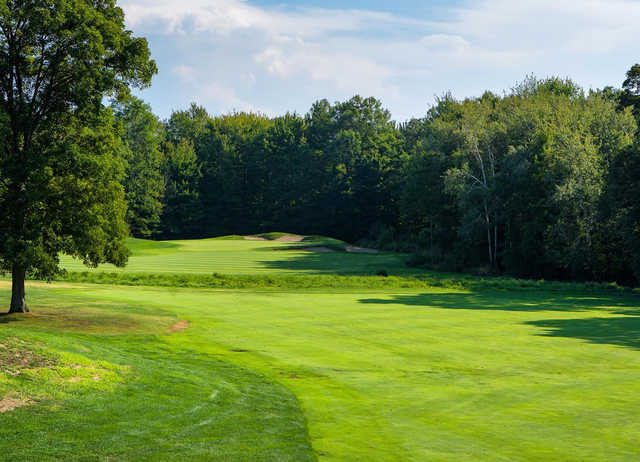 A sunny day view of a well protected hole at The Ravines Golf Club.