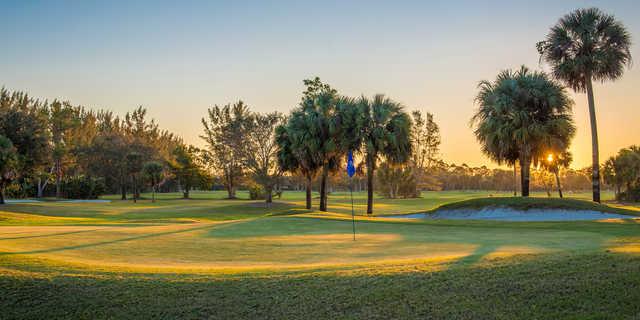 A sunset view of a green at Palm Beach National Golf Course.