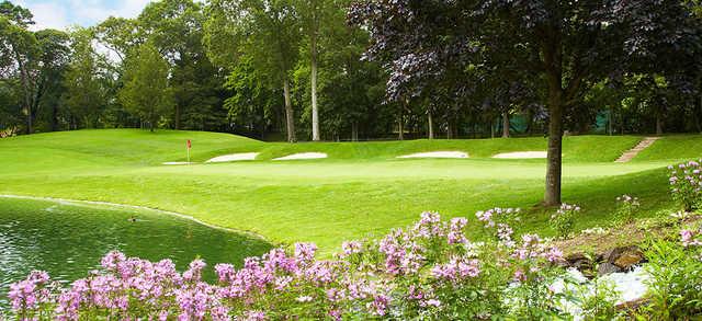 A view of a green surrounded by bunkers and flowers at Wind Watch Golf & Country Club..