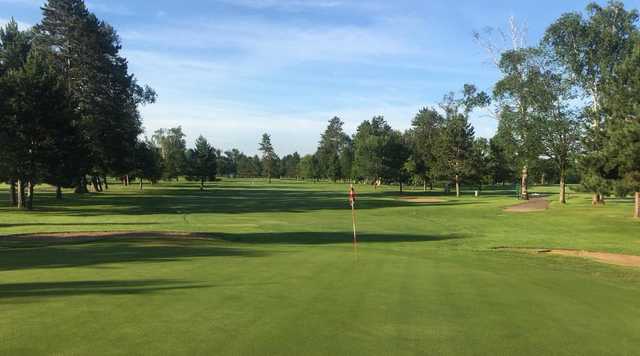A sunny day view of a green at Swan Lake Country Club.