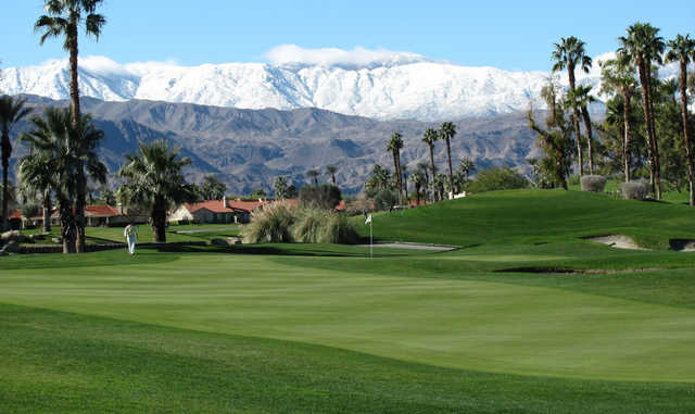 A view of a green and snowy mountains in background at Desert Falls Country Club.