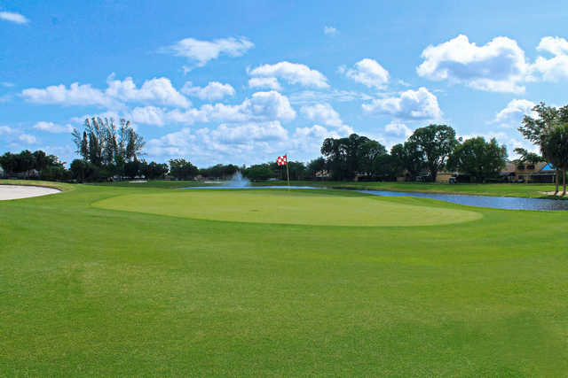 A view of a green with water in background at Pembroke Lakes Golf & Racquet Club.