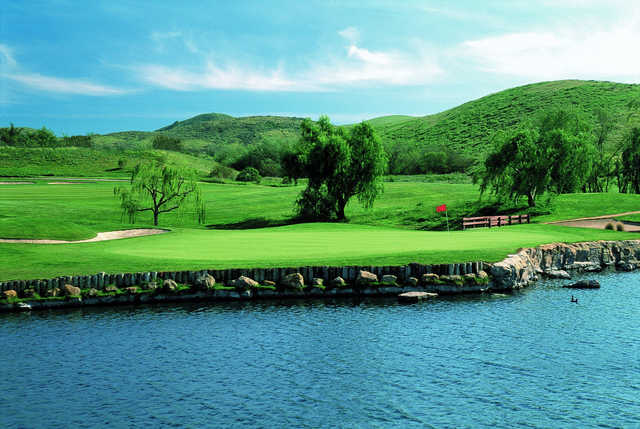 A sunny day view of a green t Wood Ranch Golf Club.