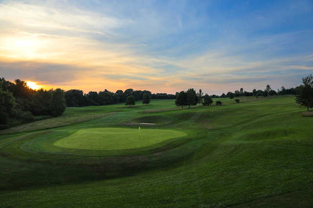 A sunset view of a green at Kingfisher Course from Mannings Heath Golf Club.