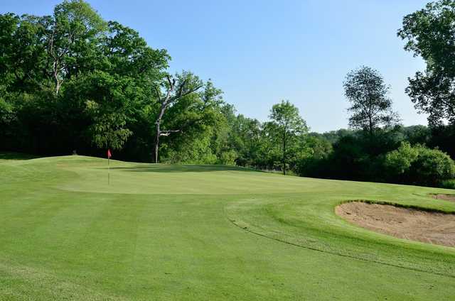 A sunny day view of a green at Chalet Hills Golf Club.