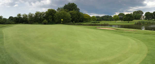 A view of a green with water in background at Streamwood Oaks Golf Club.