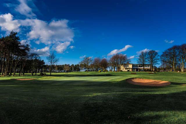 A sunny day view of a hole and the clubhouse in the distance at Westerhope Golf Club.