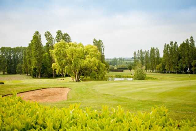 A summer day view of a green at Three Locks Golf Club.