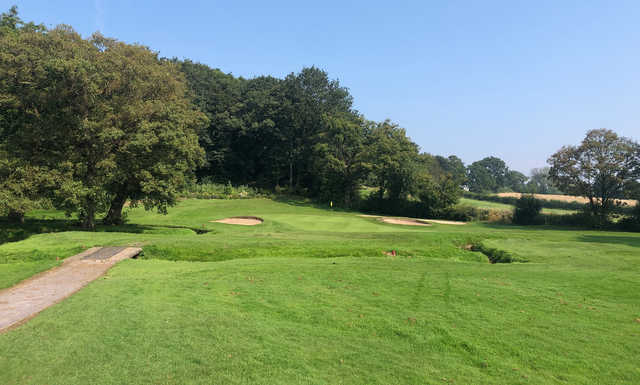 A view of a green flanked by bunkers at Alderley Edge Golf Club.