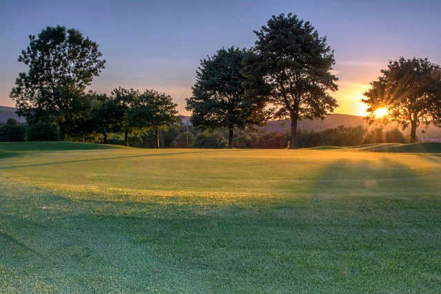A sunset view of a green at Buxton & High Peak Golf Club.