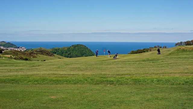 A view of a green with water in background at Ilfracombe Golf Club.