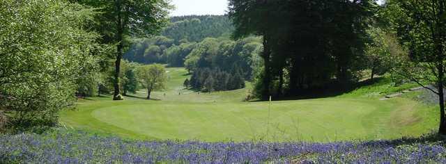 A view of a green surrounded by flowers at Sidmouth Golf Club.