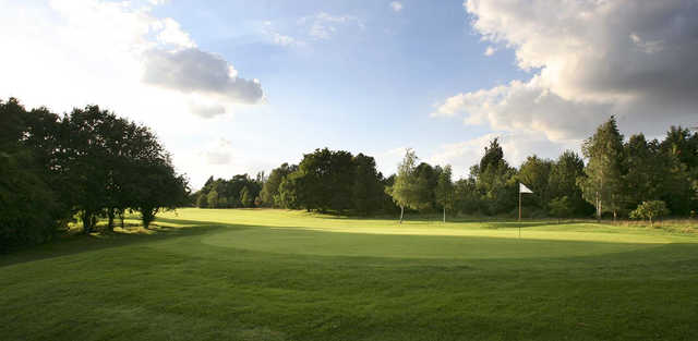 A sunny day view of a hole at Woodcote Park Golf Club.