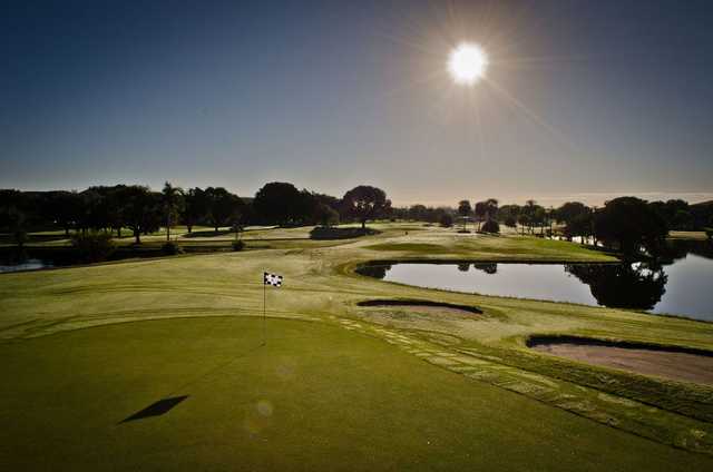 A view of green guarded by bunkers and water at Flamingo Lakes Golf & Country Club 