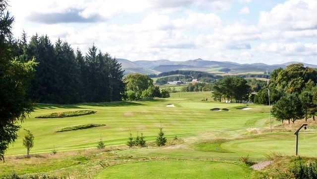 A sunny day view of a hole at Hawick Golf Club.