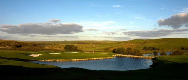 A view of a hole surrounded by bunkers and water at Rhondda Golf Club.