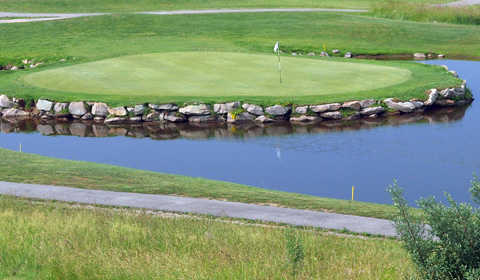 A view of the 14th hole surrounded by water at Raven Rock Golf Course