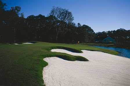 A view of green surrounded by bunkers with water coming into play from right at Crescent Pointe Golf Club