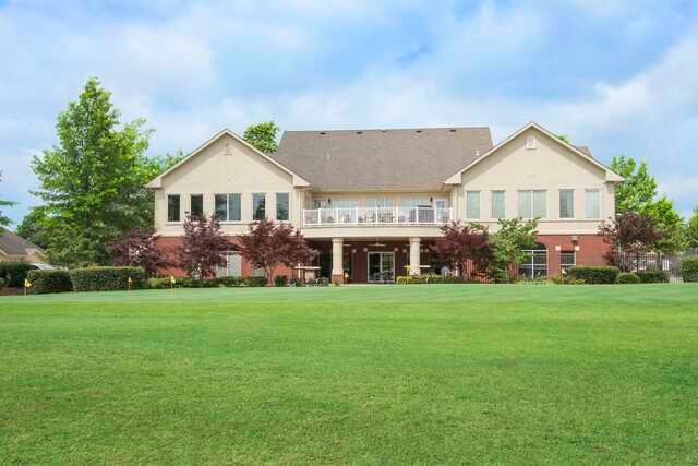 A view of the clubhouse and practice putting green at Links at Bentonville Golf & Athletic Club