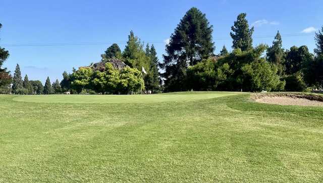 A view of a green protected by a bunker at Rancho Del Rey Golf Club.