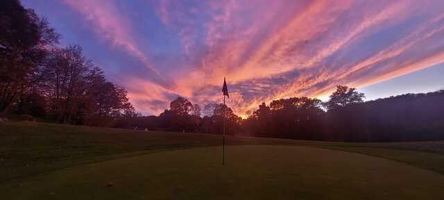 A sunset view of a green at Twin Lakes Golf Course.