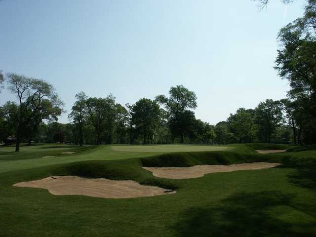 A view of a green protected by bunkers at Ravisloe Country Club