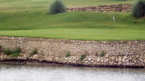 A view over the water of a green from The Golf Club at the Resort
