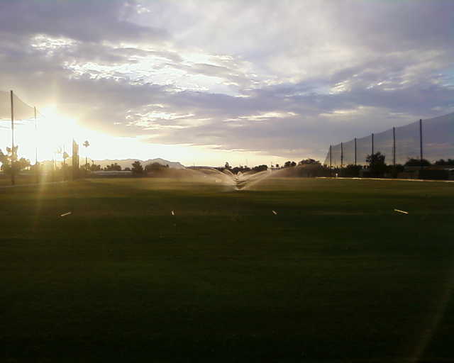 A sunny view of the driving range at Desert Sands Golf Course