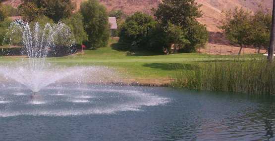 A view of a green with beautiful water fountain in foreground at Shandin Hills Golf Club.