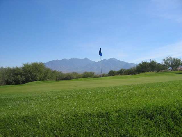 A view of a green with mountains in background at San Ignacio Golf Club