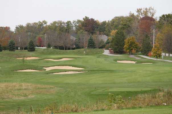 A view of a green surrounded by sand traps at West Chase Golf Club