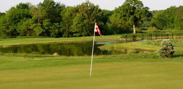 A view of green with water in background at Eagle Hills Golf Course