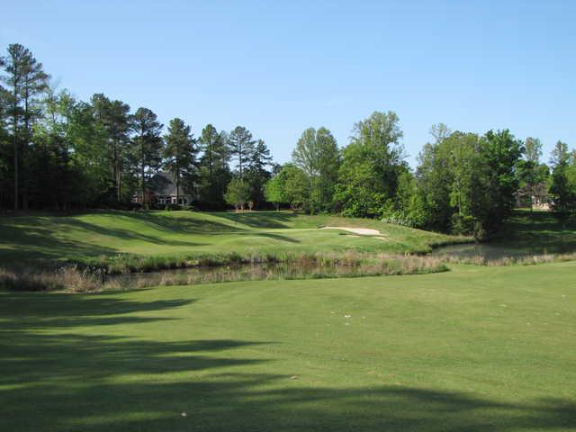 A view of a green protected by bunkers at River Falls Plantation