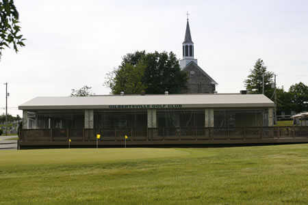 A view of the clubhouse and practice putting green at Gilbertsville Golf Club