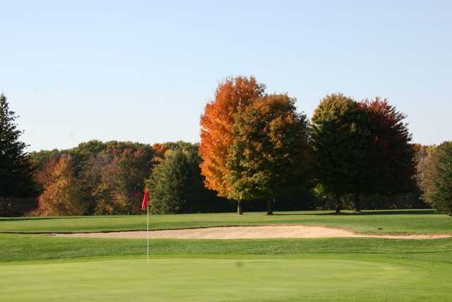 A fall view of a green guarded by bunker at Tyler Creek Golf Club