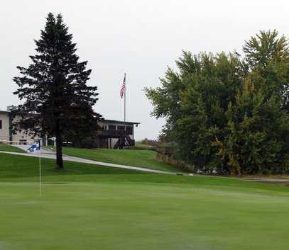 A view of a hole with clubhouse in background at River Edge Golf Course