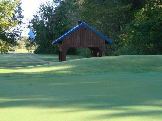 A view of a hole with a narrow road in background at Timber Truss Golf Course.