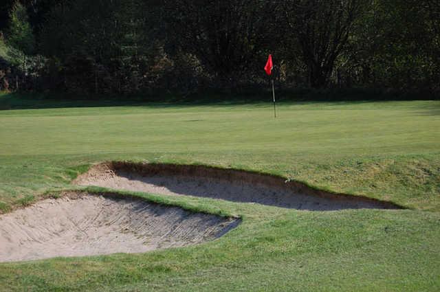 A view of a green guarded by sand traps at Alness Golf Club.