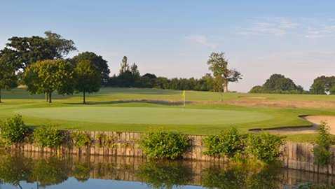 A view over the water of green protected by bunkers at Spey Valley Golf Course