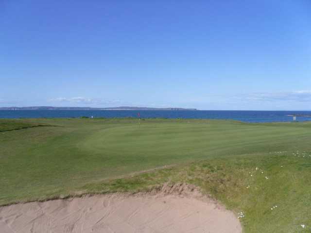 A view of green with water in background at Ballycastle Golf Club