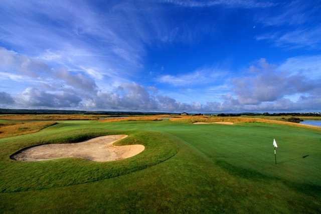 A view of a green guarded by bunker at Machynys Peninsula Golf & Country Club