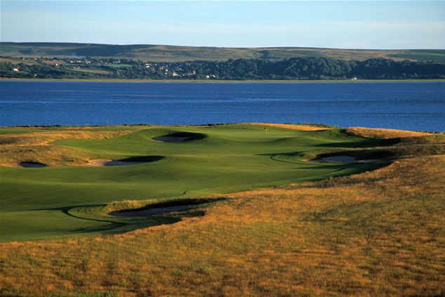 A view of a hole with water in background at Machynys Peninsula Golf & Country Club
