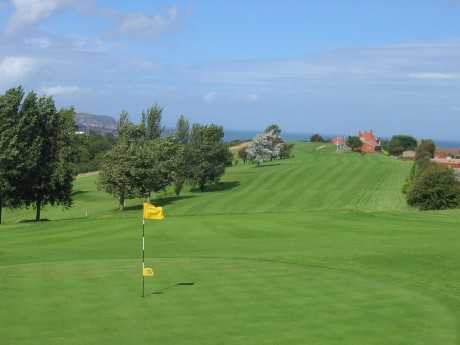 A view of a green and a fairway in the background at Old Colwyn Golf Club.