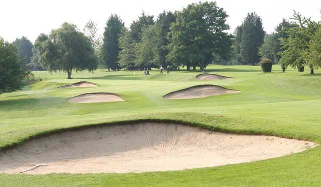 A view of a green protected by bunkers at Flackwell Heath Golf Club.