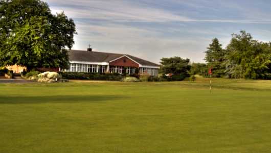 A view of the clubhouse with green in foreground at Crewe Golf Club