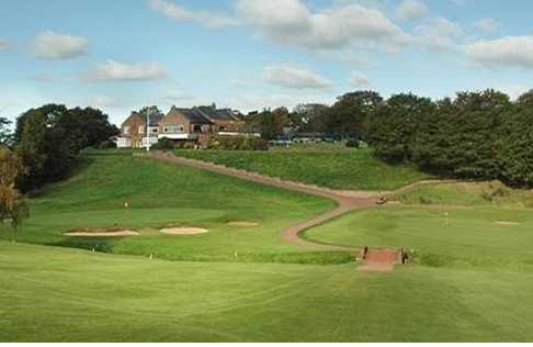 A view of green with clubhouse in background at Wilmslow Golf Club