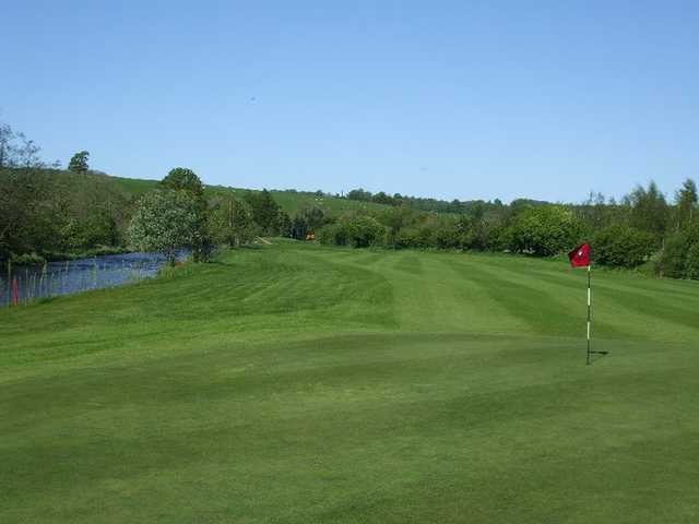 A view of green and fairway with water on the left side at Carus Green Golf Club